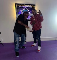 two men standing in front of a purple room