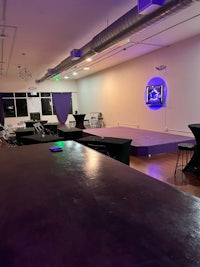 a room with tables and chairs and a purple light